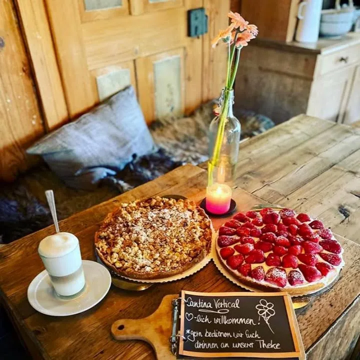 Zwei Kuchen, Kaffee und handschriftliche Willkommenstafel der Cantina Vertical