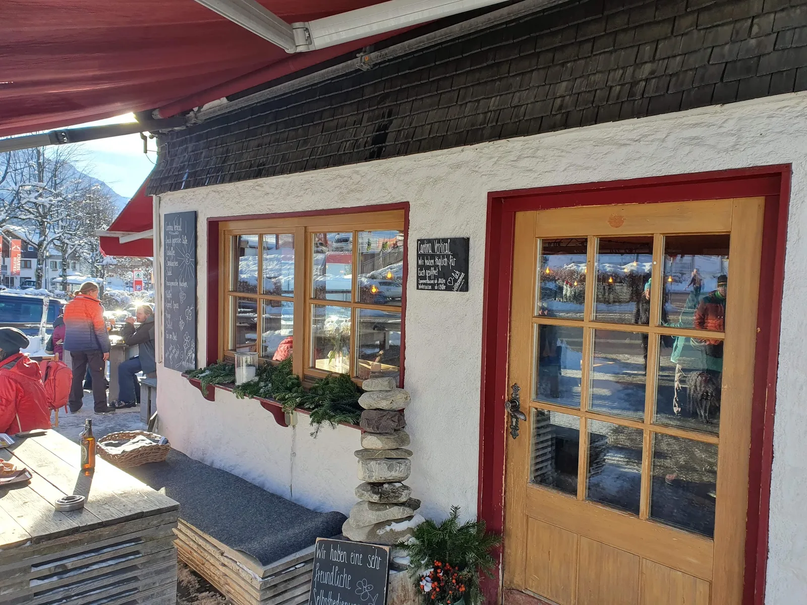 Eingang der Cantina Vertical mit Sitzbank und handschriftlichen Tafeln im Winter